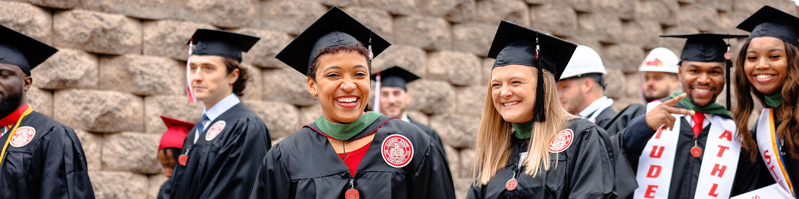 Students walking wearing gown and cap on graduation day